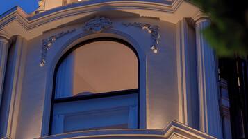 An ornate architectural structure with a large arched window and decorative moldings.