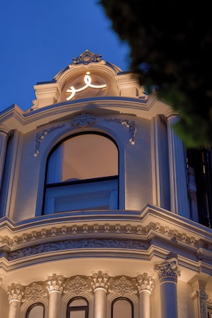Una estructura arquitectónica ornamentada con un amplio ventanal y molduras decorativas.