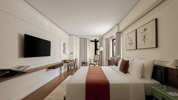 A hotel room with a large bed, a desk with a chair, a television, and artwork on the walls.