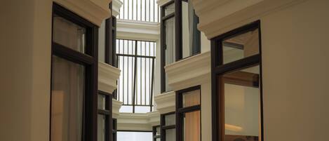 A multi-level interior corridor with multiple windows and a central open space.
