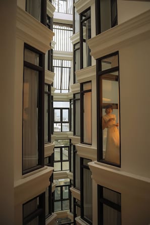 A multi-level interior corridor with multiple windows and a central open space.