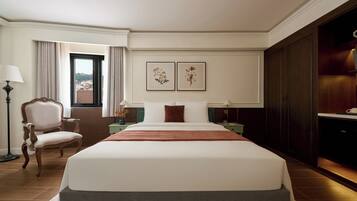 A hotel room with a large bed, a chair, a desk, a lamp, and a view of the outside.