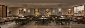 A hotel dining area with multiple tables and chairs, wall-mounted lamps, and framed artwork. - Signature by M Village The Central Da Lat, a brand of Modern Village Lifestyle (Da Lat)