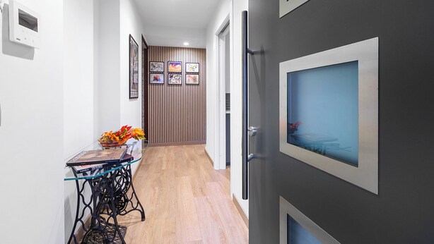A hallway with a table, framed pictures, and a door with a window. - Appartamento Girasole with Terrace, Torino, Italy (Torino)