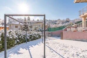 A snow-covered outdoor area with a metal structure, possibly a pergola, and a building with a balcony. - Appartamento Girasole with Terrace, Torino, Italy (Torino)