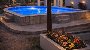 A swimming pool with steps leading into it, surrounded by a garden with colorful flowers. - Rancho Ajaw - Ajaw Kún Siuite Premium Hut 🌿 (Leona Vicario)