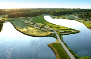 En golfbane med vandhuller og en tydelig vej.