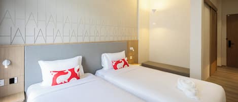 A hotel room with two beds, a wooden headboard, a wall with geometric patterns, and a door leading to another room.