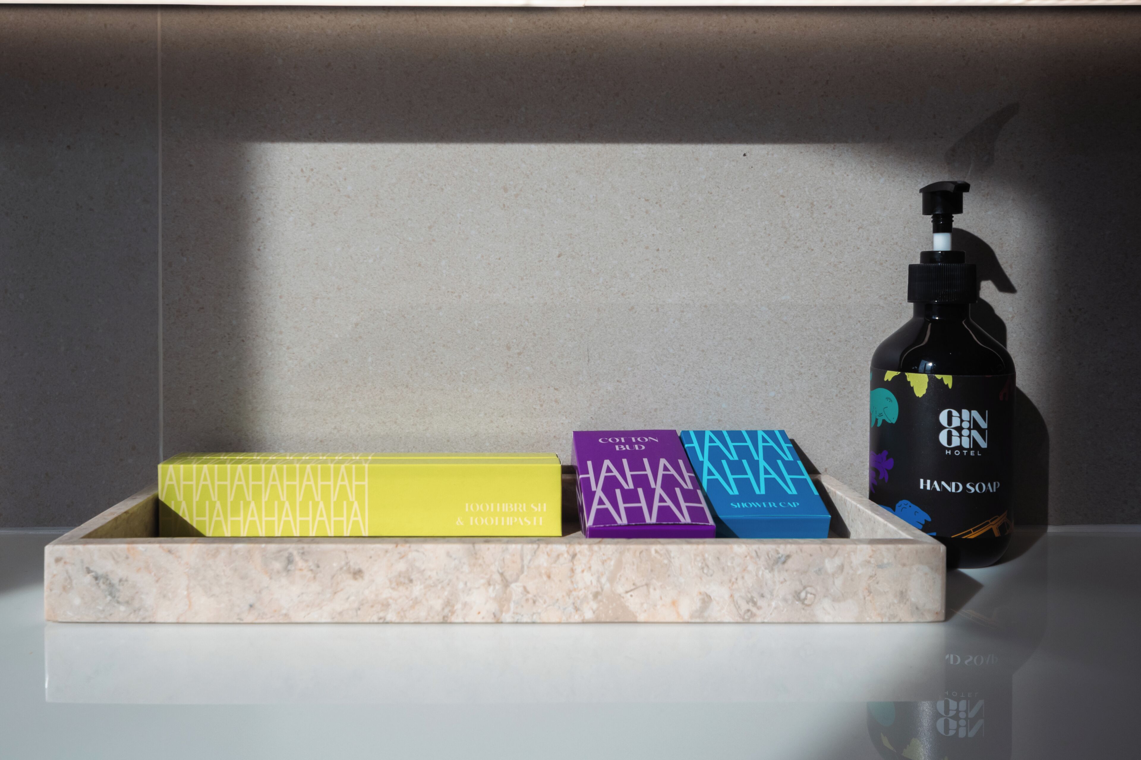 A bathroom shelf with three toiletry boxes and a bottle of hand soap.