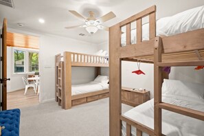 A room with bunk beds, a ceiling fan, a desk, and a window with blinds. - Lake Austin Bungalow | Private Dock + Swim Off the Dock (Austin)