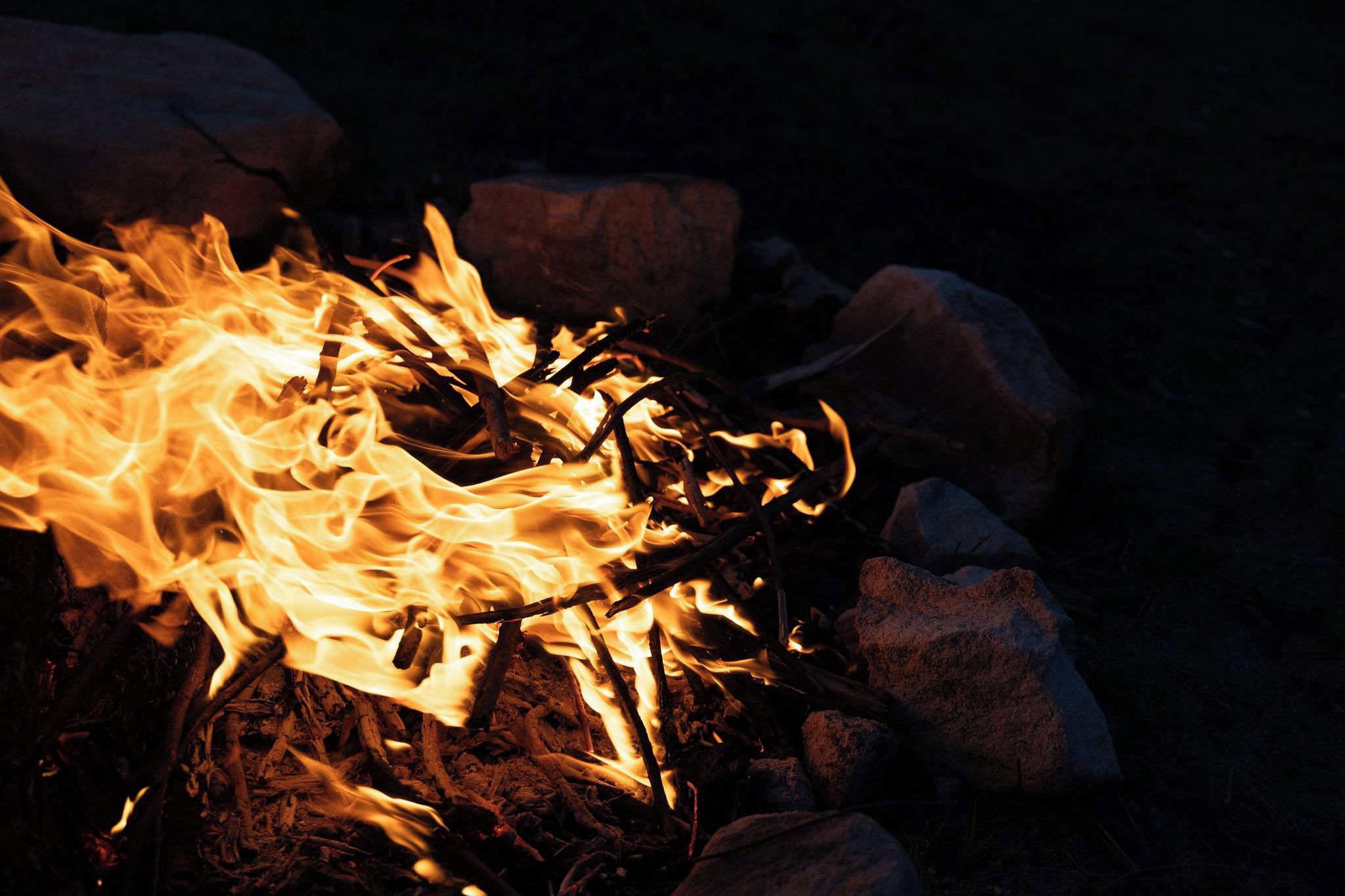 A campfire with logs and rocks.