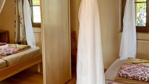 Ein Schlafzimmer mit Baldachinbett, Nachttisch und Stuhl.
