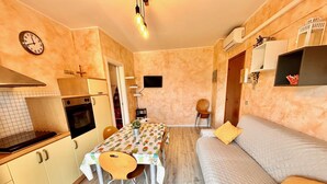 A compact living space with a kitchenette, dining area, and a sofa. - BILO PESARO MARCELLI - Two-room apartment with a/c just a stone's throw from the sea and the center (Marcelli)