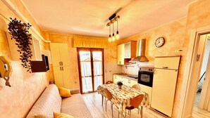 A compact kitchen with a dining area, a sofa, and a bed. - BILO PESARO MARCELLI - Two-room apartment with a/c just a stone's throw from the sea and the center (Marcelli)