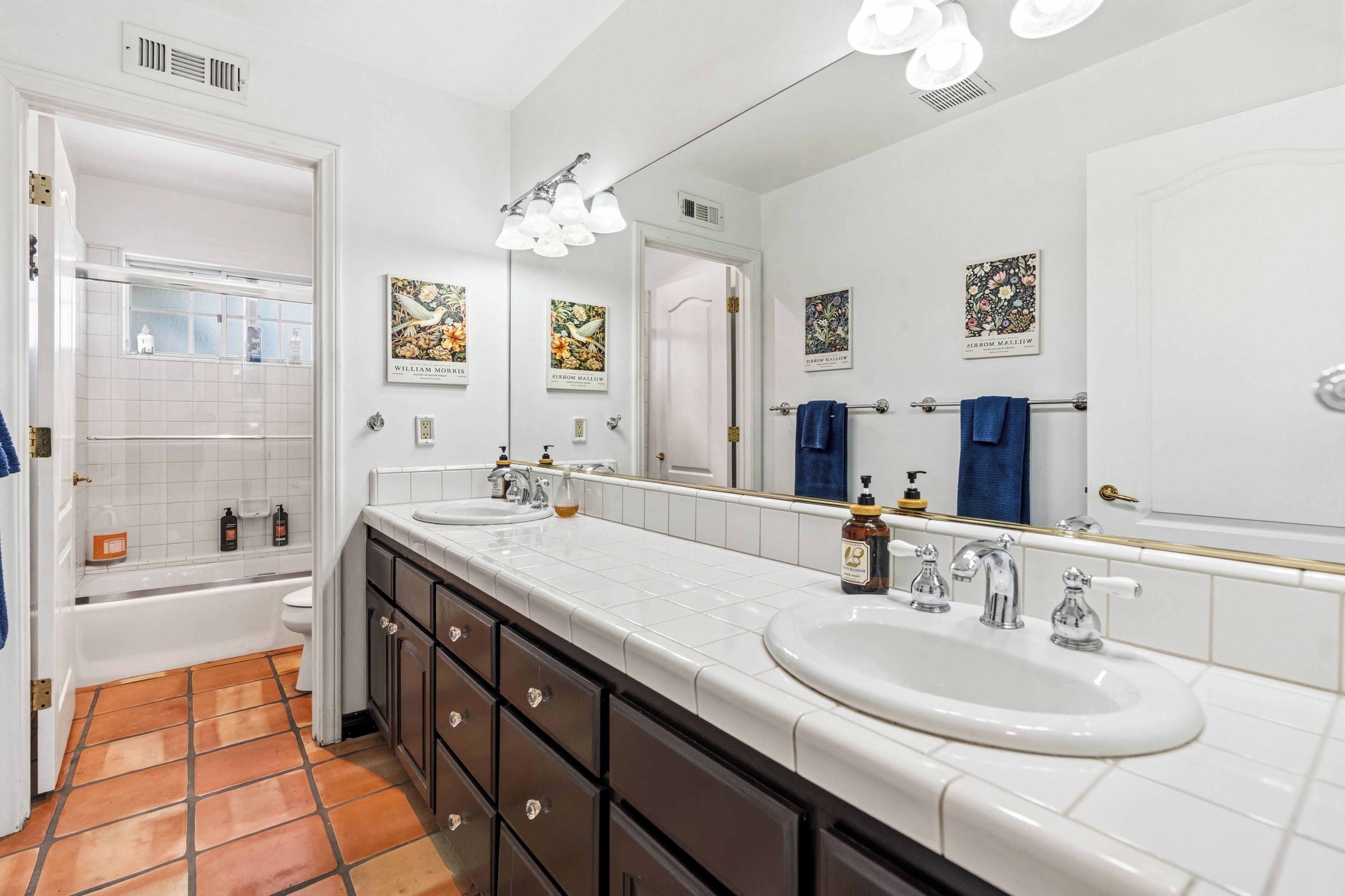Une salle de bain avec deux lavabos, un grand miroir et une baignoire.