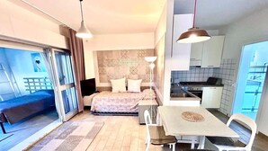 A compact living space with a bed, a dining table, chairs, a kitchenette, and a sliding glass door leading to an outdoor area. - Delightful cottage with garden and terrace overlooking the sea (Numana)