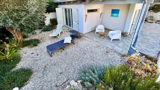 A small house with a patio, a sliding door, and a small garden area. - Delightful cottage with garden and terrace overlooking the sea (Numana)