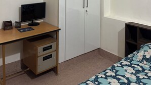 A bedroom with a bed, a desk with a computer, and white wardrobes. - Tremendous 1-bedroom house in vibrant Bengaluru awaits you (Bengaluru)