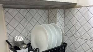 A kitchen with a dish rack holding plates, cups, and utensils. - Tremendous 1-bedroom house in vibrant Bengaluru awaits you (Bengaluru)