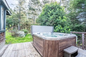 A hot tub on a wooden deck with a view of a forested area. - a luxurious and elegantly appointed 4-bed, 4-bath home situated on 1.83 acres (Little River)