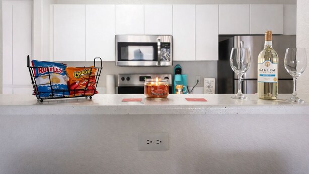 A kitchen counter with snacks, a candle, and a bottle of wine. - Cozy 2B2B in Downtown PHX • Near Airport • Perfect Work or Getaway• (Phoenix)