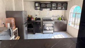 A kitchen with a refrigerator, stove, sink, and cabinets. - QUINTA ANUBIS (Oaxtepec)