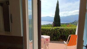 Une salle de bain avec un lavabo et une fenêtre donnant sur un patio équipé d’une chaise et d’une table.