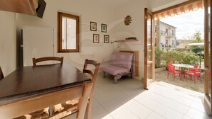 A room with a dining table, chairs, a bed, a window, and a view of the outside. - Aurora Celeste - Goelba (Campo nell'Elba)