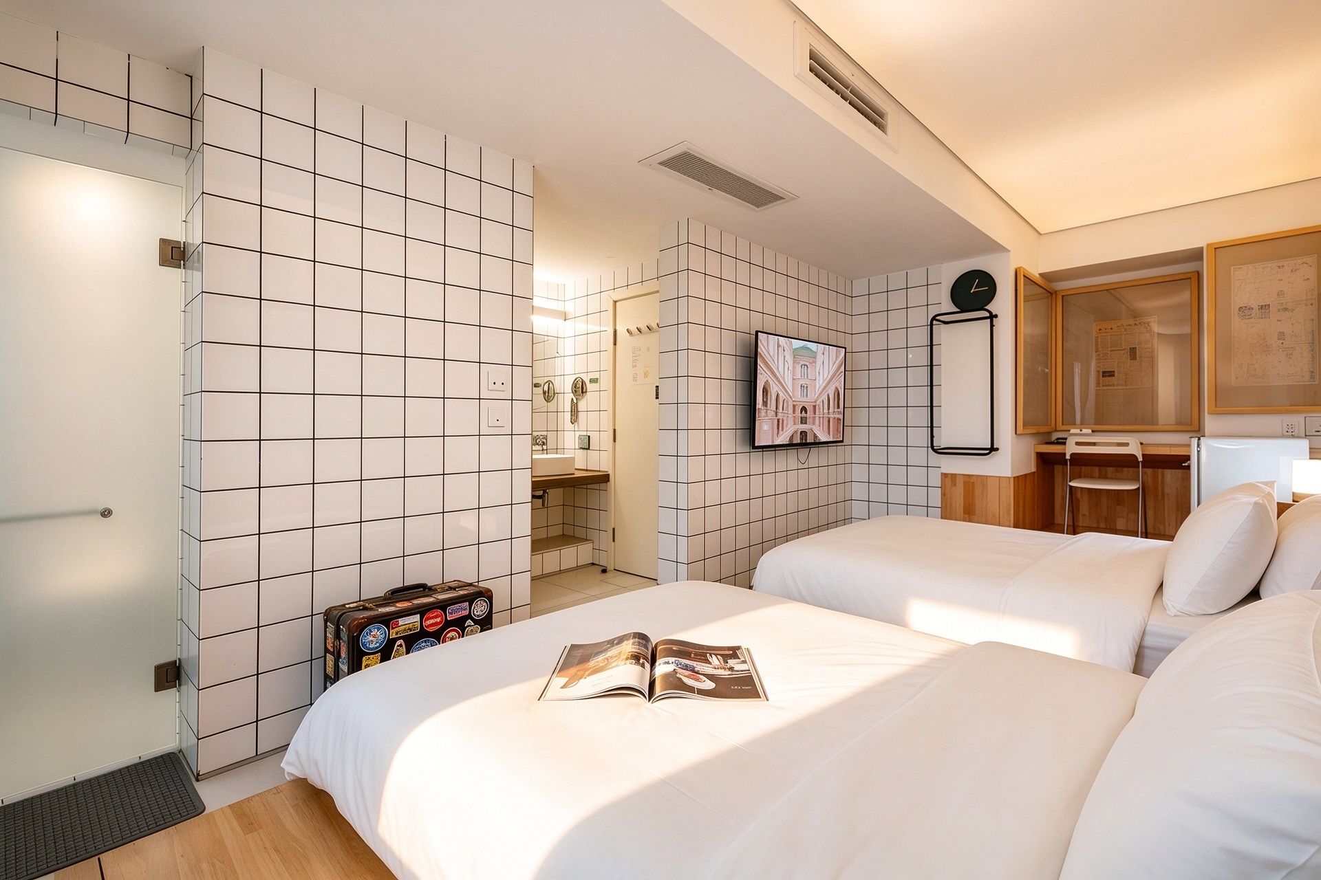 A hotel room with a bed, a desk, a chair, a television, and a wardrobe.