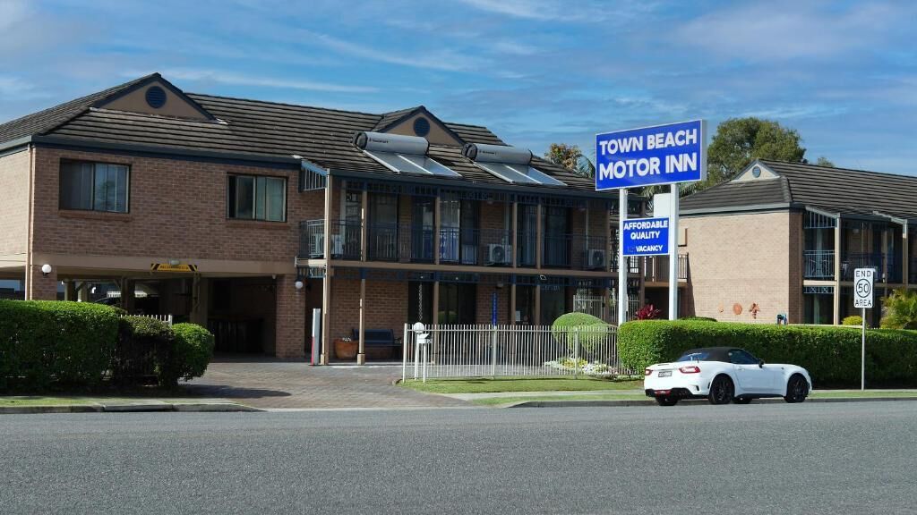 A two-story motel with a sign reading 'Town Beach Motor Inn.'