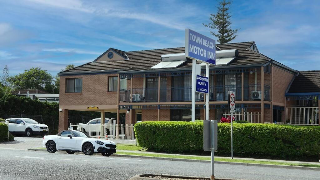 A two-story building with a sign indicating 'Town Beach Motor Inn' and a 'Vacancy' sign.