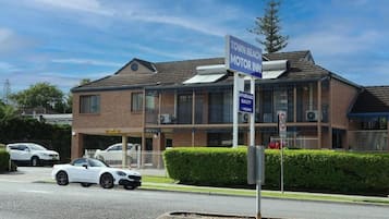 A two-story building with a sign indicating 'Town Beach Motor Inn' and a 'Vacancy' sign.