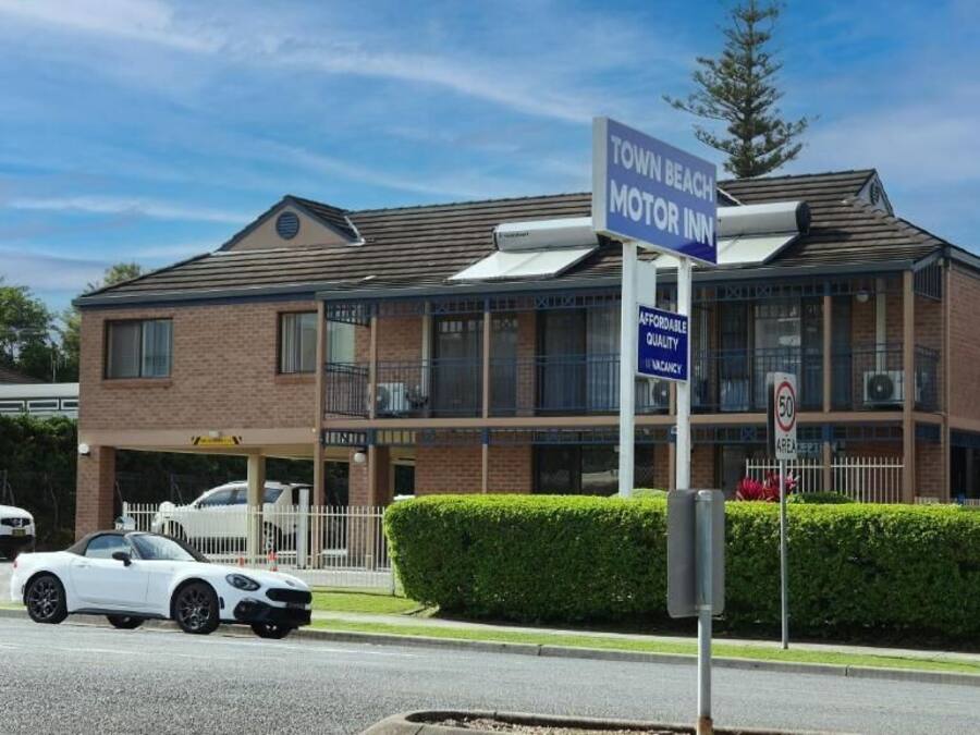 A two-story building with a sign indicating 'Town Beach Motor Inn' and a 'Vacancy' sign.