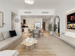 A modern living room with a sofa, coffee table, and a TV mounted on the wall. - 2-bedroom apartment in Dubai, near Dubai mall, Burj Khalifa and Fountains (Dubai)