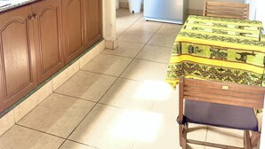 A kitchen with wooden cabinets, a stainless steel refrigerator, a microwave, and a dining table with chairs. - Colonial Apt for 7 · Private Terrace · 3 Bedrooms · 9 Blocks from Main Square (Salta)