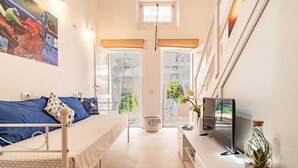Un dormitorio con cama, televisión y ventana.