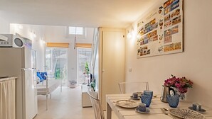 Una cocina moderna con comedor, que cuenta con un amplio ventanal, un refrigerador y un menú colgado en la pared.