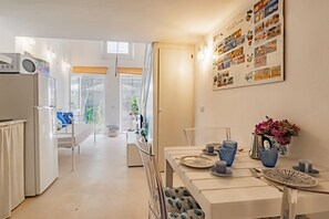 Eine moderne Küche mit Essbereich, ausgestattet mit einem großen Fenster, einem Kühlschrank und einer an der Wand befestigten Speisekarte.