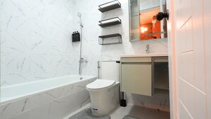 Een badkamer met een bad, toilet en wastafel.