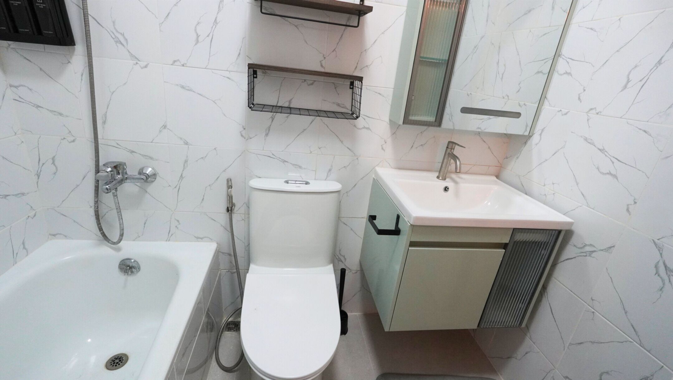 A bathroom with a bathtub, toilet, sink, and a mirror.