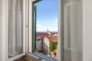 A window with a view of a cityscape, including buildings and a clear sky. - EA Blue Marin Apartment With A/C (Sanremo)