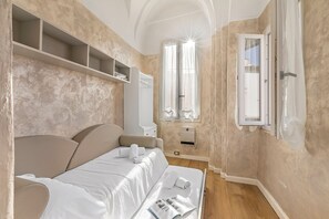 A bedroom with a bed, a bedside table, a wardrobe, a window with curtains, and a door. - EA Blue Marin Apartment With A/C (Sanremo)