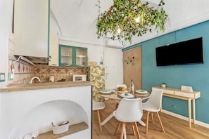 A modern kitchen with a microwave, sink, and a dining area with a table and chairs. - EA Blue Marin Apartment With A/C (Sanremo)