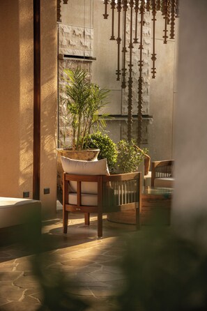 Un interior moderno con una planta en maceta, muebles de madera y suelo de piedra.