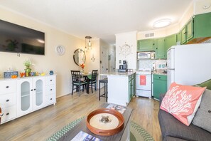 A compact living space with a dining area, kitchenette, and seating area. - Panoramic Gulf Views Private Balcony Steps from Babe’s Beach & Fishing Pier+WiFi (Galveston)