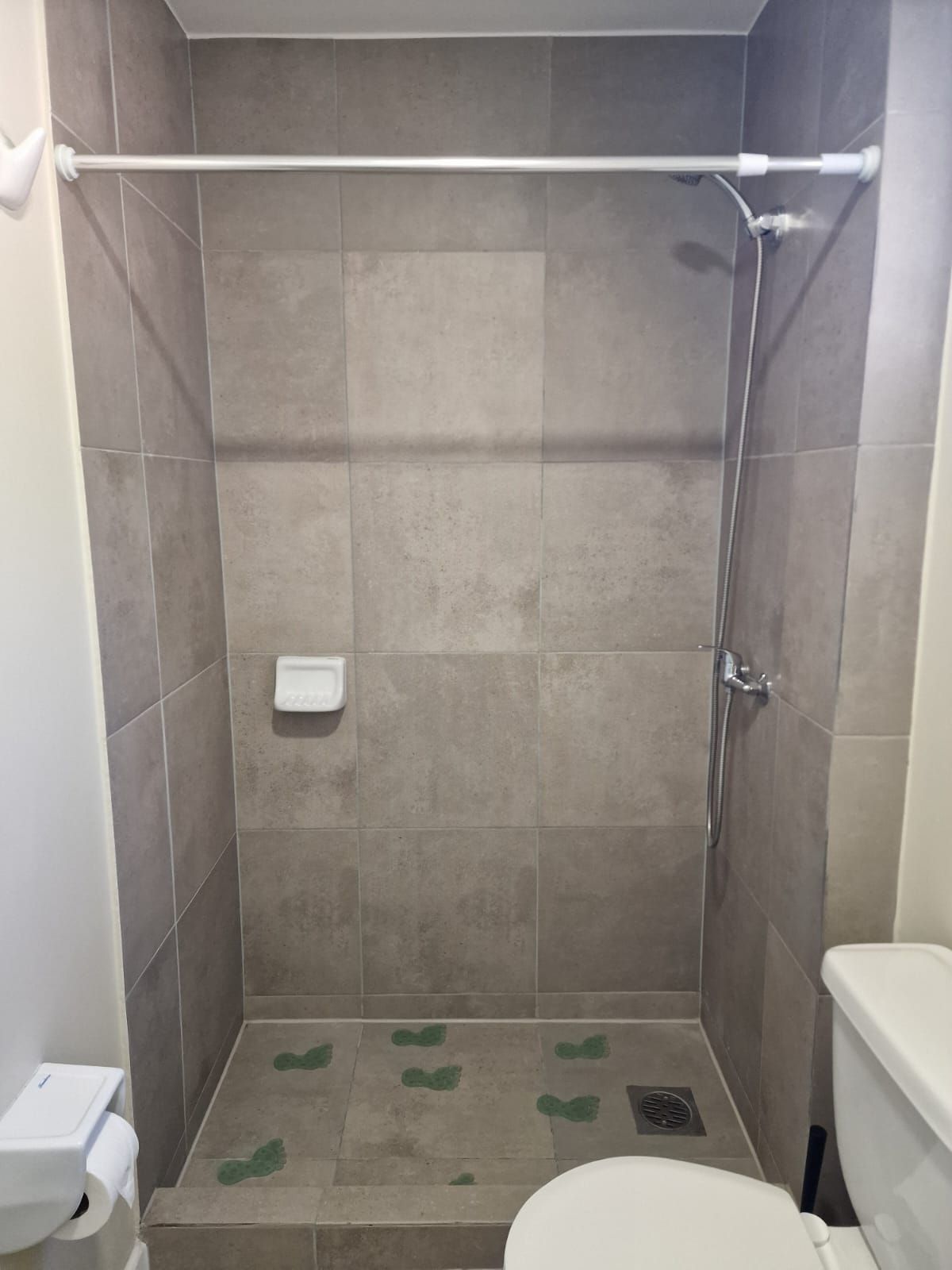Une douche avec des toilettes blanches et un distributeur d ’essuie-tout.