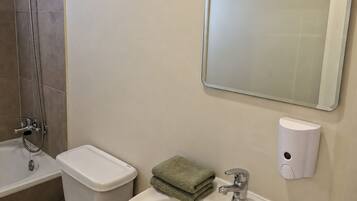 Un baño con inodoro, lavabo, espejo y bidé.