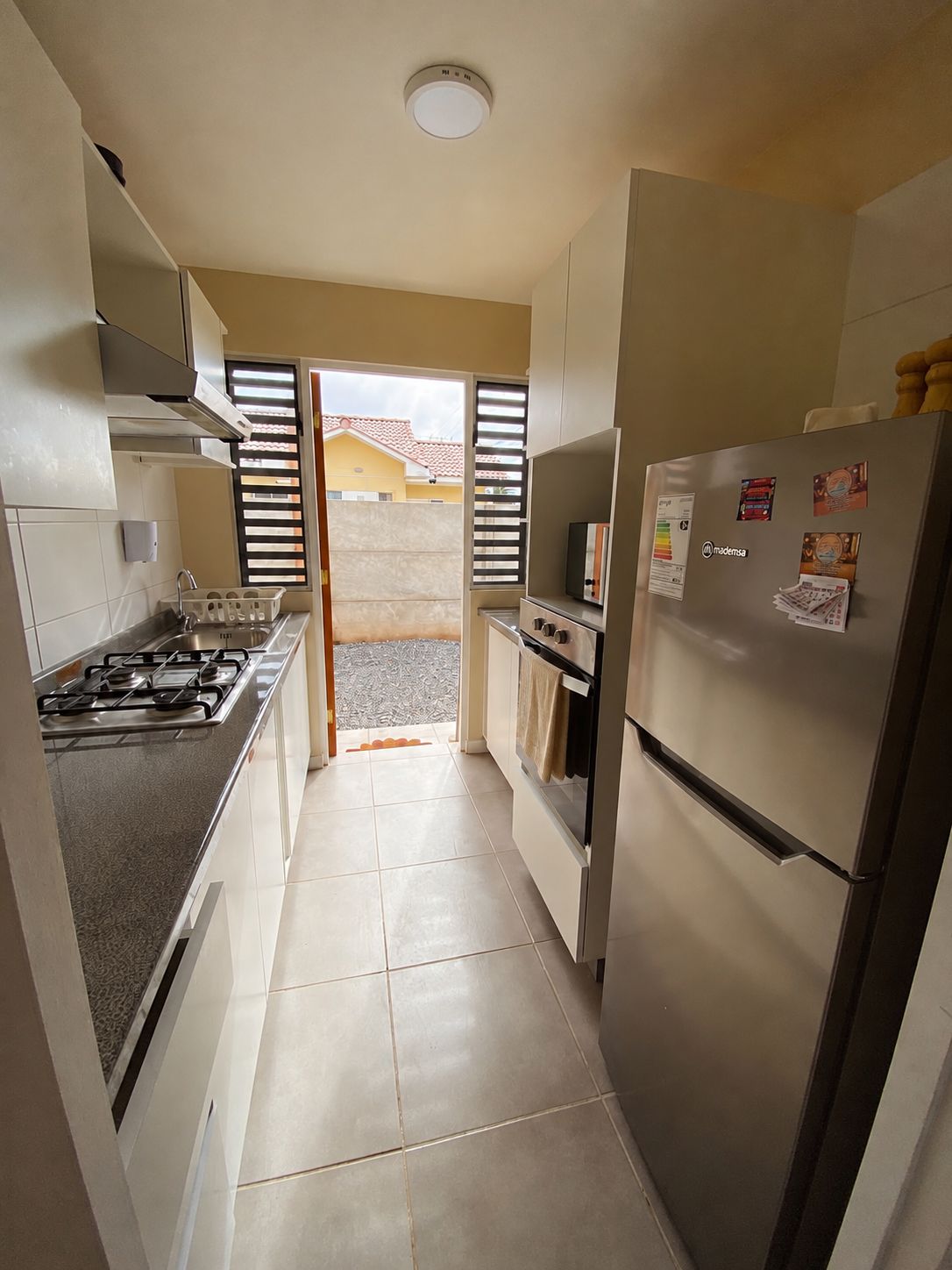 A kitchen with a gas stove, oven, and refrigerator.