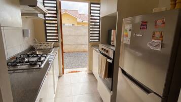 A kitchen with a gas stove, oven, and refrigerator.