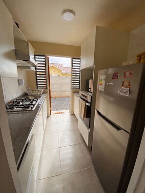 A kitchen with a gas stove, oven, and refrigerator. - 🏡 New & Secure Home with Parking | Near Casino Enjoy, Portillo  & Hot Springs (Calle Larga)